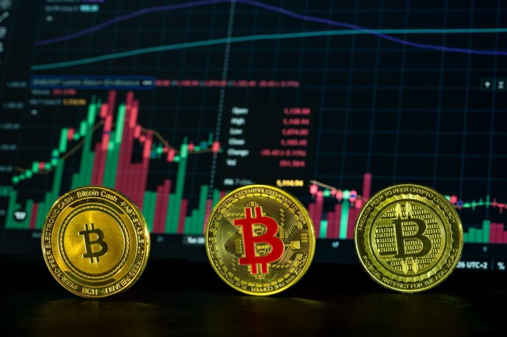 Close-up of bitcoin coins in front of a financial market graph, symbolizing digital investment trends.